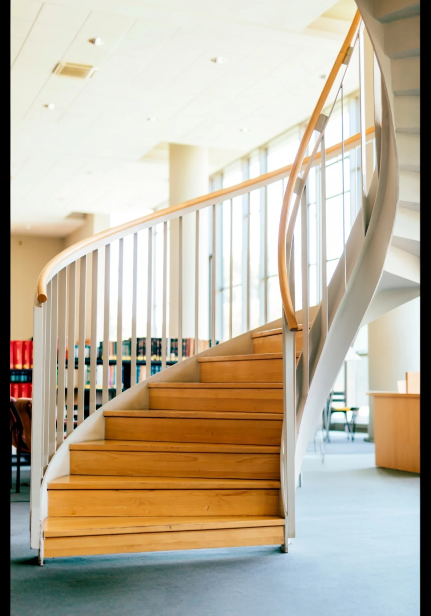 A sophisticated curved staircase with light wood treads